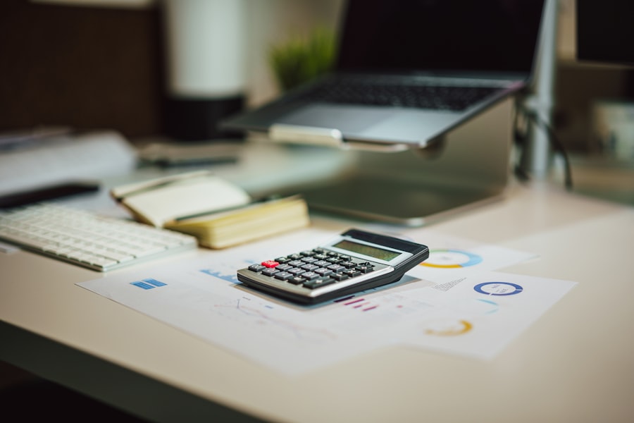 Calculator sitting on top of printed financial charts on a desk